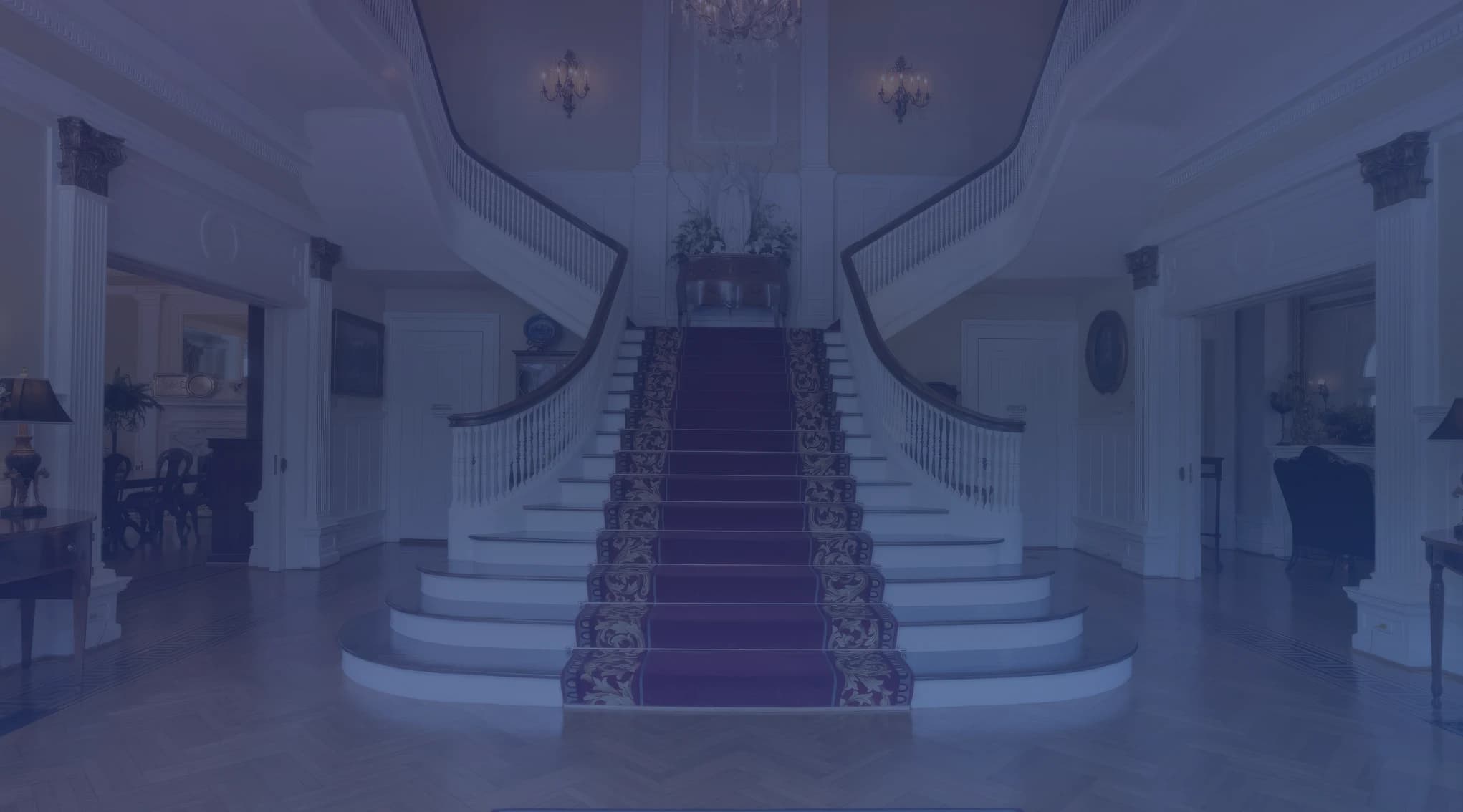 Sweeping double staircase with red carpet runner in the grand foyer of the Alabama Governor Mansion in Montgomery
